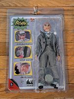 Front view of the Mad Hatter action figure in sealed plastic packaging with backing card showing character images and branding.