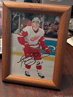Framed photo of Boyd Devereaux in Detroit Red Wings uniform with autograph visible.