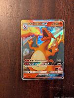 Front of Charizard GX Pokémon card showing holographic image, HP, and attack moves