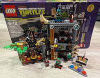 LEGO Teenage Mutant Ninja Turtles 79103 Turtle Lair Attack boxed set shown with built lair and accessories.
