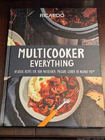 Front cover of the hardcover cookbook showing the title and food imagery