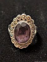 Front view of silver ring showcasing oval smoky quartz surrounded by floral silver detail.