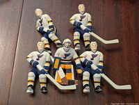 Five St. Louis Blues hockey player figurines arranged front facing showing detailed paint and colors