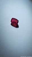 Cushion cut natural red ruby gemstone shown from different angles on white background, highlighting color and cut.
