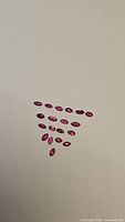 Group of 22 natural untreated marquis cut rubies arranged on a light surface showing size and color consistency.