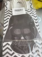 Two black and white gift bags featuring zigzag patterns with large dark mask graphics on the front, sealed in original packaging with white rope handles folded inside.