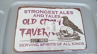 Front of the metal sign showing the Old Crow Tavern design with crow and skull graphic