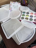 Photo of 5 varied silicone molds and a 15-color glitter palette on a table surface