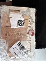 Photo of the date night dice game in sealed plastic packaging showing the cardboard backing with game name, instructions, and decorative text including 'PLAY GAMES' and 'SNUGGLE'.