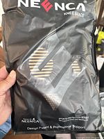 Front of packaging showing NEENCA branding and product name Knee Brace. Packaging is black with printed graphics.