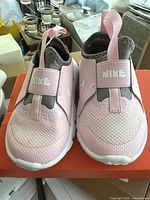 Front view of the pink Nike Flex Runner 2 (TDV) kids shoes showing the mesh upper, strap with NIKE branding, and grey inner lining.