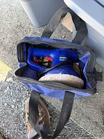 Top view of blue Simoniz electric polisher inside blue carry bag with items placed on the ground.