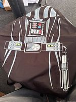 Full view of Darth Vader themed apron in black and grey polyester, showing printed detailed chest panel and belt design.