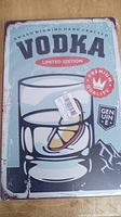 Rectangular metal sign with vintage vodka design featuring glass with lemon, text and graphic elements in multicolor.