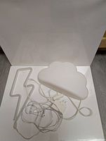 Photo showing the IKEA cloud lamp and the lightning bolt neon light with cords and USB connectors.