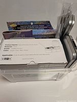 High performance brush cleaner box with a 12-color assorted semi-precious stone paint palette on top, a clear plastic bin holding metal tins with craft brushes.