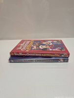 Two Disney Christmas DVD cases stacked with spines facing outward, showing titles 'Very Merry Christmas Sing-a-Long' and 'One Magic Christmas'