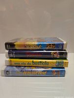 Stack of four VHS tapes showing spine labels with French and live-action Disney titles