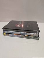 Four DVDs stacked flat including The Secret, two Flipper DVDs, and Babe Collector's Edition.