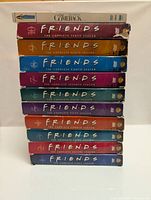 Stack of DVD box sets with titles visible for Friends seasons 1 through 10 and Lisa Kudrow's The Comeback season 1.