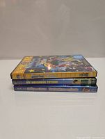 Stacked DVD cases showing three kids cartoons DVDs: Sabrina the Teenage Witch, My Neighbor Totoro, and All Dogs Go to Heaven.