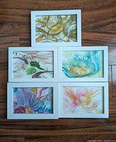Lot of 5 framed original abstract ink paintings by Jose Laberge displayed together on wood background.
