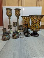 Complete set of 20 Party Lite stained glass style candle holders arranged on floor, showcasing large hurricane holders, medium votives, small candle holders, and metal candelabra.