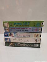 Stack of five children's movie VHS tapes with visible spine titles, including Dr. Seuss's ABC and One Fish Two Fish Red Fish Blue Fish.