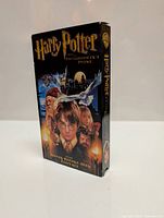 Front of VHS case showing Harry Potter and the Philosopher's Stone artwork, prominently featuring Harry Potter and Hogwarts with the indication of never before seen footage.