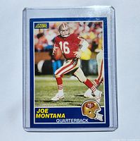 Front of 1989 Score Joe Montana football card showing player in red San Francisco 49ers uniform, number 16, mid-play with football.