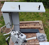 Side view of the fundus camera system mounted on a metal stand with handles, showing the optical and mechanical components.