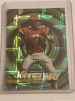 Front of John Elway 1995 Collector's Edge holographic football card in protective plastic sleeve.