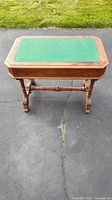 Image of the Victorian writing desk showing the green felt inset on the rectangular top with ornate wood edges and drawer.