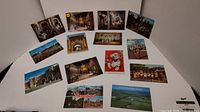 Photo showing various vintage postcards spread on a white surface, including Disneyland, architecture, and character postcards.