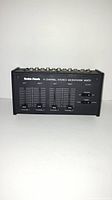 Front view of a vintage Radio Shack 4 channel stereo microphone mixer showing sliders, switches, and labeling.