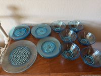 Top view showing all items including five small bowls, three small plates, and two larger plates in aqua blue glass with hobnail pattern.