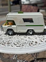 Side view showing white and green painted pressed steel body with windows and wheels.