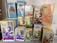 Front view of multiple original Robert Raikes Bears boxes stacked and arranged, showing different editions and years.
