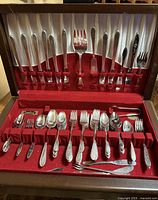 Full view of the mixed Holmes & Edwards silver plated flatware set displayed in a red felt-lined case showing dinner knives, forks, spoons, and serving pieces.