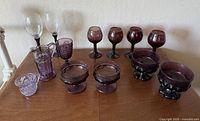 Overview of all glassware items on display showing different styles and sizes in purple and clear glass.