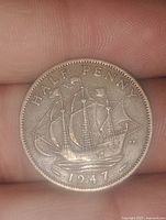 Reverse of 1947 English half penny coin showing sailing ship and date 1947