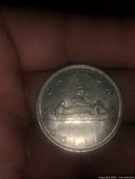 Reverse image showing canoe with two paddlers and year 1968 on Canadian dollar coin.