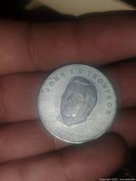 Obverse side of the coin showing raised portrait of John G. D. Thompson with inscription and year 1992.