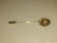 Side angle photo of the stick pin showing the faux tiger eye stone and metal bezel detail.