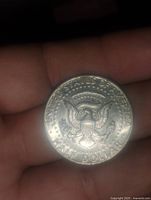 Reverse side of the 1974 Kennedy half dollar coin showing the presidential seal and inscriptions.