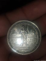 Front side of the coin showing a miner holding tools with inscriptions about metals: platinum, silver, copper, and iron, along with mining infrastructure in the background.