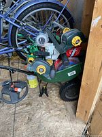 Photo showing Scotts broadcast spreader alongside multiple lawn sprinklers and other gardening tools.