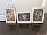 Photo showing three framed Persian inspired artworks arranged on dark wood floor against white backdrop.