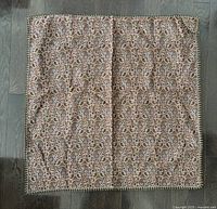 Tablecloth with detailed Persian inspired pattern, intricate design in brown, beige, and black tones, square shaped with decorative edge trim.