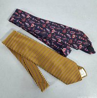 Two vintage ties laid flat, showing whole length and patterns.